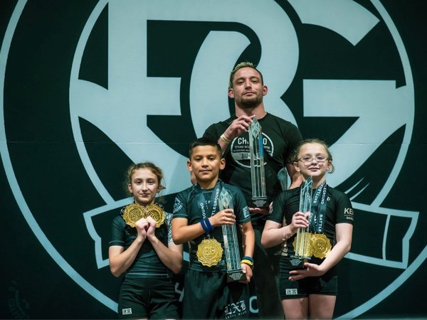 Young Labyrinth BJJ athletes holding medals and trophies